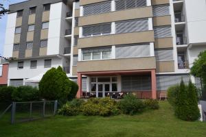 ein Apartmenthaus mit Rasen davor in der Unterkunft Mladinski dom - Hostel in Klagenfurt am Wörthersee