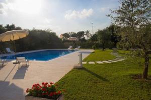 podwórko z basenem i parasolem w obiekcie Agriturismo Dell'Orto Apartments w Weronie