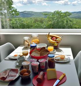 a table with breakfast food and a window with a view at B&B On The Rocks in Blizna Donja