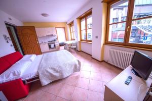1 dormitorio con 1 cama y TV. en Sweet Spot en Riva del Garda