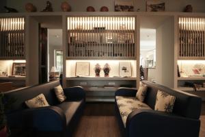 a living room with two couches and a table at Hotel Lucerna in Castiglione della Pescaia