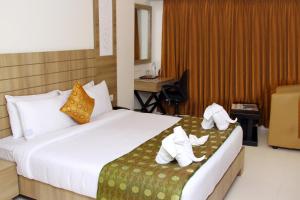 een hotelkamer met een bed met twee olifanten erop bij Vinayaga by Poppys ,Kumbakonam in Kumbakonam