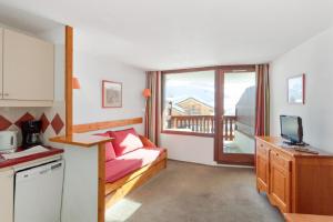 a small room with a bed and a kitchen at Residence Les Melezes - maeva Home in L'Alpe-d'Huez