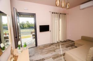 a living room with a couch and a tv at Villa Saravari in Áyios Aléxandros