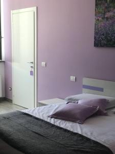 una camera da letto con un grande letto con pareti viola di Bed & Breakfast Oltrepo a Casteggio