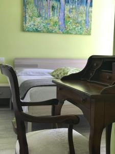 una camera con letto, scrivania e pianoforte di Bed & Breakfast Oltrepo a Casteggio