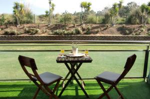 a table with two chairs and two glasses of wine at The Surf Studio - Ericeira in Ericeira