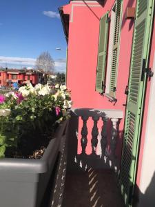 un balcone con fiori e una casa rosa di Bed & Breakfast Oltrepo a Casteggio