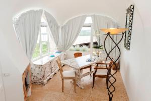 a dining room with a table and chairs and windows at Villa Anna in Porto Cervo