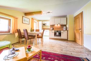 een woonkamer met een tafel en een keuken bij Brollerhof in Neustift im Stubaital