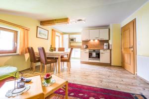 a living room with a table and a kitchen at Brollerhof in Neustift im Stubaital