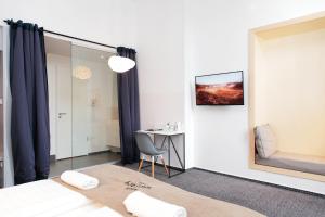 a bedroom with a bed and a table and a mirror at Maverick Budapest Soho in Budapest