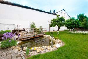 a garden with a wooden bridge over a pond at Pension Eichschmid / Röll´n Biergarten in Bad Gögging