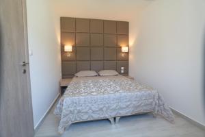 a bedroom with a large bed with two pillows at Dionisos Resort in Pefkochori