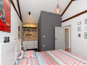 a bedroom with a king sized bed and a stone wall at Apartment Gaia in Funtana