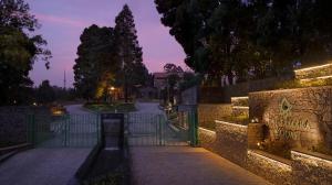 a gate to a park at night with a fence at The Tamara Kodai in Kodaikānāl