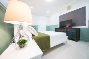 1 dormitorio con 1 cama con lámpara y TV en The Partridge Guesthouse en Cebú