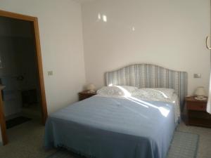 una camera da letto con un letto con una coperta blu sopra di Scalas House a Nurachi