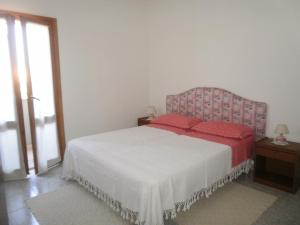 een slaapkamer met een bed met rode kussens erop bij Scalas House in Nurachi