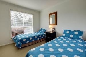 a bedroom with two beds and a window at SPINNAKER 1 in Elizabeth Beach