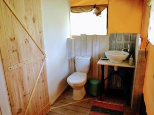La Fortinerie Glamping Safari Tent with Hot Tub في Mouliherne: حمام مع مرحاض ومغسلة