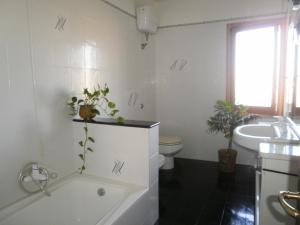een badkamer met een bad, een toilet en een wastafel bij Scalas House in Nurachi