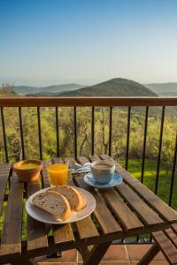 a table with a plate of bread and cups of coffee at Os Feleitos in Orellán