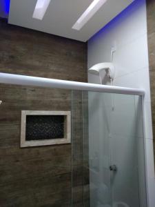 uma casa de banho com um chuveiro e uma cabina de duche em vidro. em Pousada Dos Comissarios em Indaiatuba