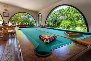 a pool table in a room with large windows at Relais Le Nereidi in San Vito lo Capo