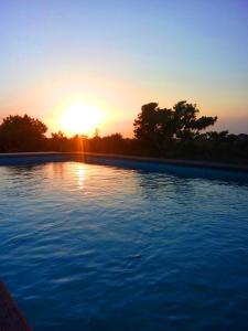 a swimming pool with the sunset in the background at VILLA Can Guillem d'es Puig in Sant Francesc Xavier