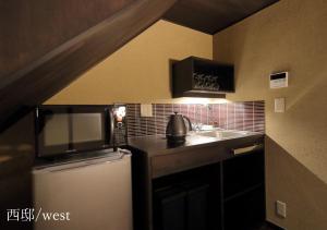 a small kitchen with a microwave and a sink at Houka in Kyoto