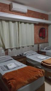 a bedroom with two beds and a fan at Pousada Dos Comissarios in Indaiatuba