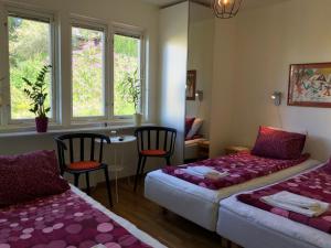 a room with two beds and a table and chairs at Sven Fredriksson Bed & Breakfast in Norrtälje