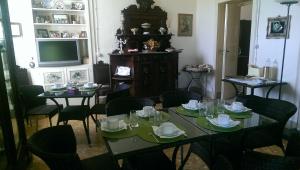 jadalnia ze stołami i krzesłami oraz telewizorem w obiekcie La Taverna w mieście Floridia