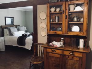 a bedroom with a bed and a wooden hutch at Makoadi Farms Guesthouse in Clocolan