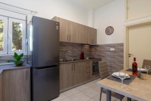 a kitchen with a stainless steel refrigerator and a table at Sweet Home Kremasti in Kremasti