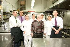 un grupo de chefs posando para una foto en una cocina en La Locanda di Gino, en Sulmona