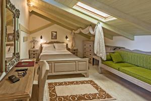 a bedroom with a bed and a green couch at Hamam Oriental Suites in Rethymno Town