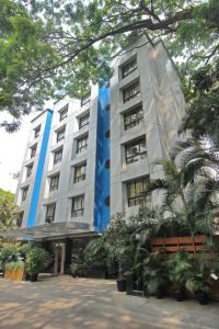 a large white building with trees in front of it at Hotel Park Central Comfort- E- Suites in Pune