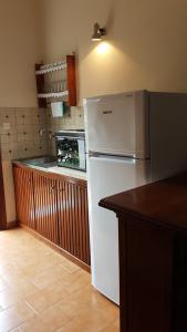 a kitchen with a white refrigerator and a counter at Castello Bellos studios in Keri