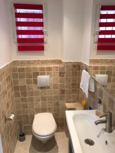 フォルカルキエにあるMaison de vacancesのバスルーム(トイレ、洗面台、赤い窓付)