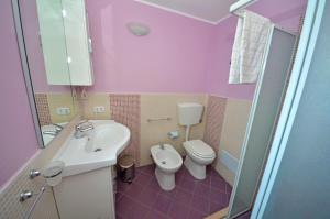 a pink bathroom with a toilet and a sink at Antica Terrazza in Morciano di Leuca