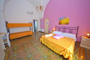 a bedroom with two beds and a purple wall at Antica Terrazza in Morciano di Leuca