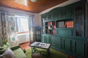 una sala de estar con un armario verde y una mesa en Turismo Rural O Xastre de Anos, en Cabana de Bergantiños