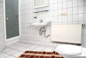 a white bathroom with a sink and a toilet at Appartements & Ferienwohnungen Wolf in Usingen +27 photos