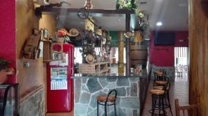a bar in a restaurant with a red refrigerator and stools at Hostal La Aldaba in Montearagón