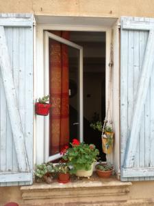 Le Thoronet Appartement في لو ثوروني: نافذة مع نباتات الفخار على حافة النافذة