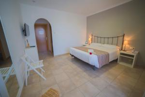 Casa Del Mar Hotel & Apartaments في روساس: غرفة نوم بسرير وطاولة وكرسي