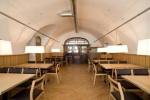 a dining room with tables and chairs and lights at Hotel Kolping Hallein in Hallein +26 photos