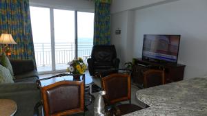 a living room with a couch and a television at Penthouse Floor 1 BR Resort Condo Direct Oceanfront Wyndham Ocean Walk - Daytona Funland 1908 in Daytona Beach